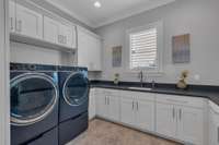 Oversized laundry room with custom cabinets and extra countertop space for folding