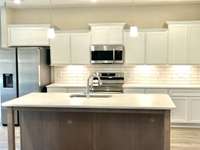 Wonderful textured backsplash highlighted by undercabinet lighting.
