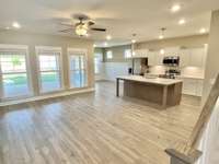 Beige or "greige" neutrals with added LED lights. View of great room, kitchen and dining area