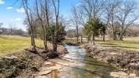 A meandering creek winds peacefully through the property, adding natural charm and tranquility to the landscape - all without the worry, as the property is not in a flood zone. A perfect blend of beauty and peace of mind.