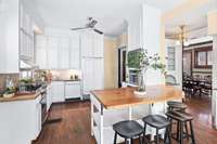 Sub zero, range, single oven, microwave, cabinets to the sky, built-in kitchen cupboard, wet bar, butcher block island.