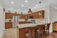 This kitchen is every cook's dream! Lots of cabinets, granite, tile back splash, under counter & above counter lighting!  Wonderful stainless appliances remain and new refrigerator!