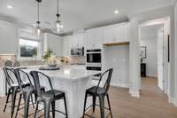 Chef's kitchen including 42" upper cabinets, SS appliances, granite or quartz countertops, and tile backsplash.