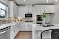 Chef's kitchen including 42" upper cabinets, SS appliances, granite or quartz countertops, and tile backsplash.