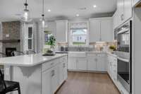 Chef's kitchen including 42" upper cabinets, SS appliances, granite or quartz countertops, and tile backsplash.
