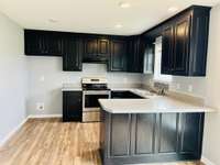 Great kitchen with new electric stove, recessed lighting