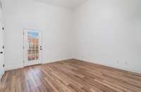 Main bedroom with new flooring, vaulted ceiling and door to deck