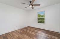 2nd bedroom with new flooring and ceiling fan