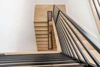 Stairs down one floor to the private owner's level with primary bedroom suite and private office