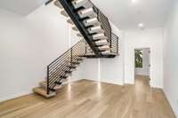 Foyer / Lobby with floating stairs and LED lighting up. 5th Bedroom or 2nd office beyond.