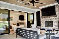 Living room opens to private back porch with wood burning fireplace and two ceiling heaters with a roll up screen and side door