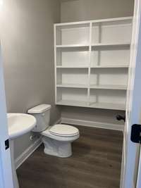 Spacious powder room with custom shelving!