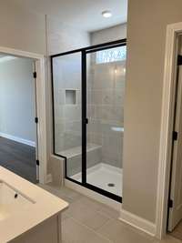 Nice shower with tiled walls and seat.