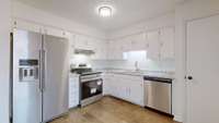 KITCHEN WITH NEW COUNTER TOP, STOVE, DISHWASHER.