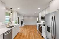 Kitchen opens into the den/dining area with a wood burning fireplace