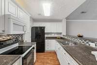 Beautiful Kitchen includes Tile backsplash, Stove, Refrigerator, Garbage Disposal, Dishwasher, Microwave, and large Pantry to the left of fridge, that also holds the washer dryer area.