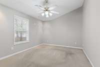 This is the Master Bedroom. With an angled vaulted ceiling for added character. And view of the back side of home, with a lovely tree line view. Also added recessed lighting, as well as ceiling fan.