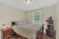 This bedroom has plenty of natural light and features hardwood flooring.