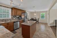 View from hallway looking at kitchen. Windows have view of back yard and deck and side yard. .
