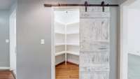 A generous pantry with built-in shelves and a beautiful sliding door.
