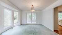 This dining room has lots of natural light. It adjoins a sunroom, and the kitchen.