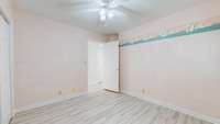This hobby room with ceiling fan and new flooring could be an office or an extra bedroom.