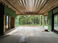 Rear Covered Porch with wood-burning fireplace * this home is under construction. Photo taken 6/17/25