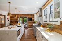 The kitchen enjoys the glowing afternoon light and opens onto the back deck for easy indoor/outdoor living!