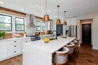 This kitchen is a show-stopper! From the 12' island with waterfall a countertop to the custom wood accent wall and gas range with double oven, it has everything you need to cook and entertain to your hearts desire!