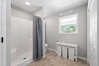 Walk in shower with bench seating.