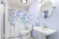 The bathroom has a walk in shower, updated high toilet, updated mirror and light