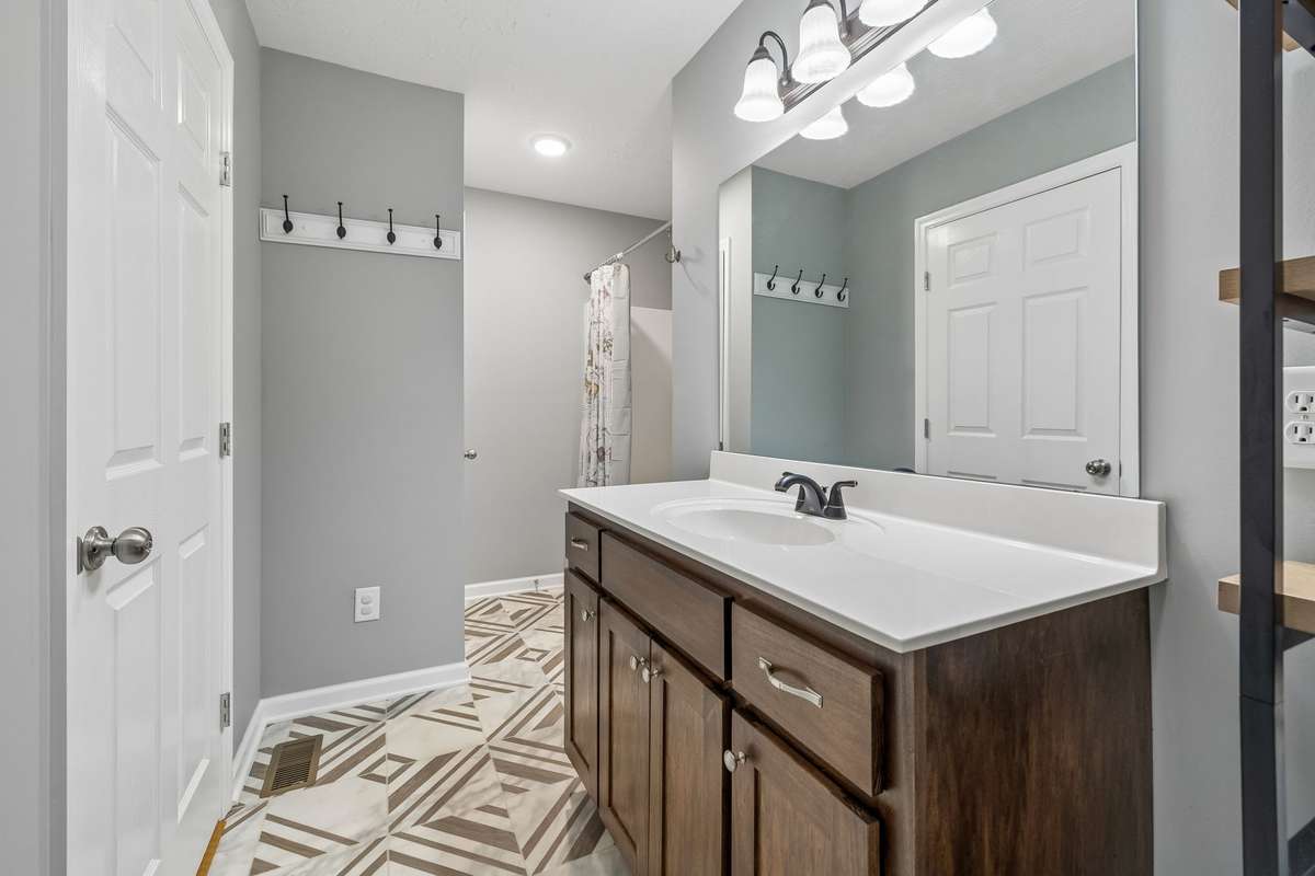 Primary bathroom with functional layout and ample storage.