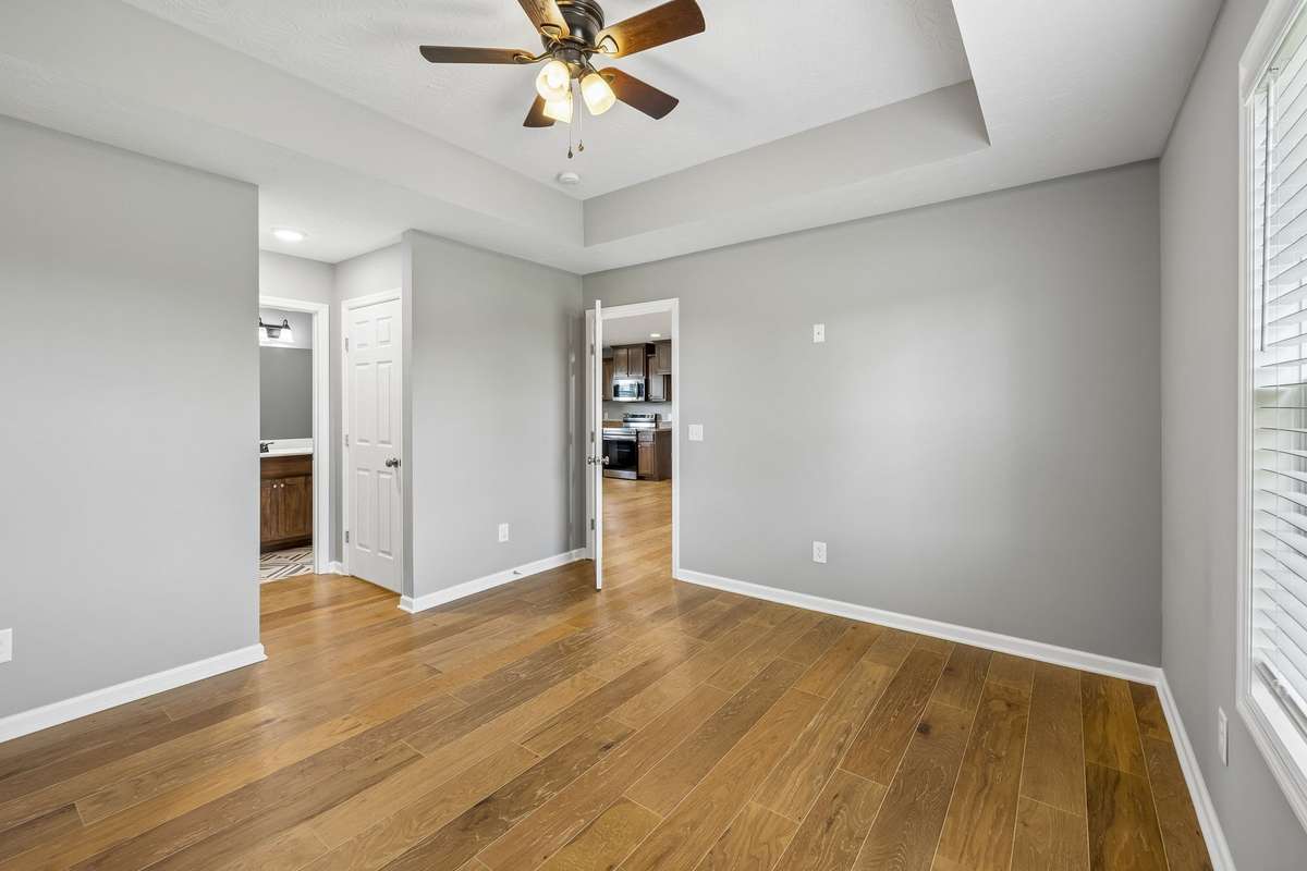 Primary suite offers generous space and access to dual walk-in closets.