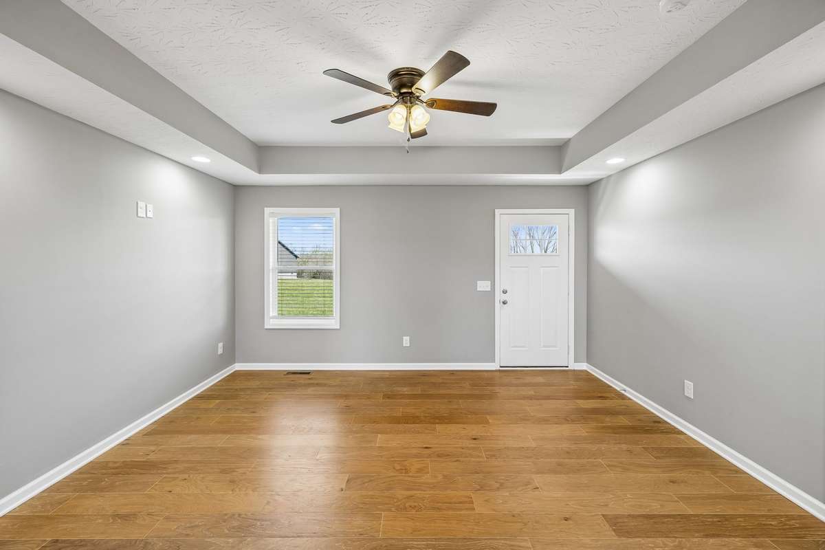 Bright and inviting living room featuring tray ceilings and an open-concept layout perfect for everyday living and entertaining.
