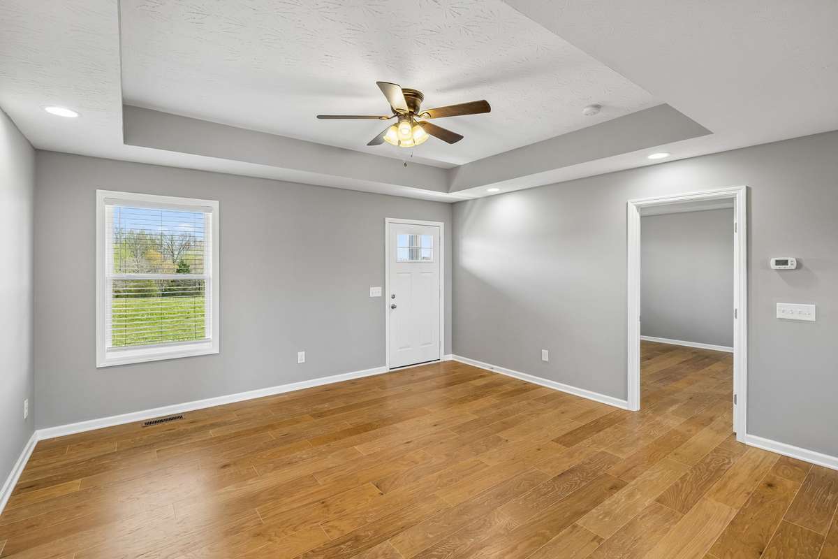 Bright and inviting living room featuring tray ceilings and an open-concept layout perfect for everyday living and entertaining.