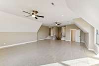 An exquisite bonus room featuring a stylish half bath, gracefully positioned above a spacious three-car garage."