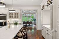 The thoughtful design of this kitchen provides access to the adjacent sunroom via two different entrances, both with hidden pocket doors.  This bar sink area allows for an additional opening to that that room but can also be closed off if desired
