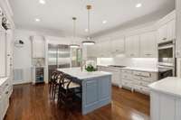 This highly functional chef's kitchen boasts custom cabinetry, new quartz countertops, new premium appliances, updated lighting and a new designer tile backspash.