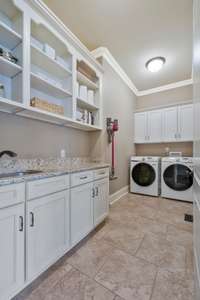 Main floor laundry room offers extra storage space in addition to the wet bar and pantry.