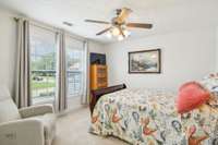 Light-filled upstairs bedroom with large windows and serene views.