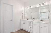 Bright primary bathroom with dual sinks and ample storage