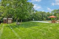 Expansive private yard backing to trees with storage shed and room to play, garden, or expand outdoor living space.
