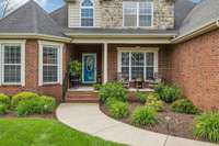 Welcoming covered front porch with rocking chairs and fresh landscaping—ideal for morning coffee or evening unwind.