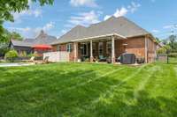 Expansive fenced yard with covered outdoor living and poolside seating.
