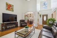 Open-concept living flows to formal dining and entry, framed by elegant columns—functional layout with timeless charm.