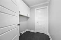 Tiled laundry room with storage