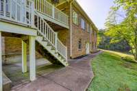 Back of home. Yard gently slopes to the wooded area and creek.