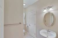 View of the guest bath with tub/toilet and additional guest vanity.
