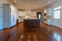 Looking toward the kitchen island, which has a sink, Fisher & Paykel dishwasher drawer & ice maker