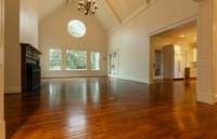 Den looks over the terrace with access to the screened porch and open to the kitchen. Fireplace on the left